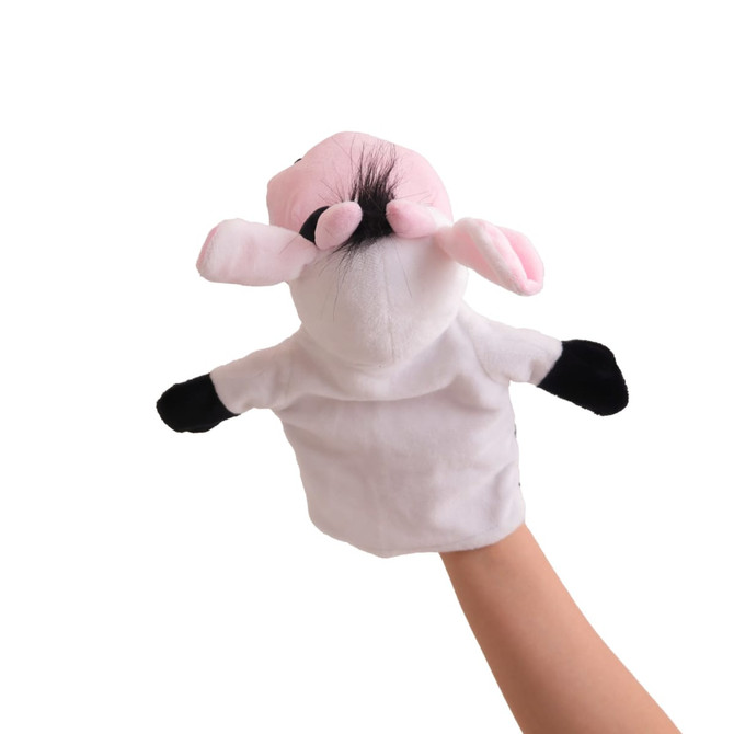 A cow hand puppet featuring pink ears, a black-and-white design, and a fluffy mane, held in a hand.