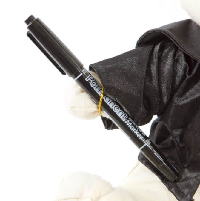 A plush bear wearing a graduation gown, holding a black permanent marker. It has a logo on the gown.