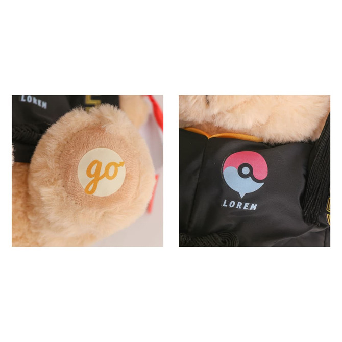 A plush teddy bear with a light brown fur, wearing a graduation outfit and featuring a logo on its ear.