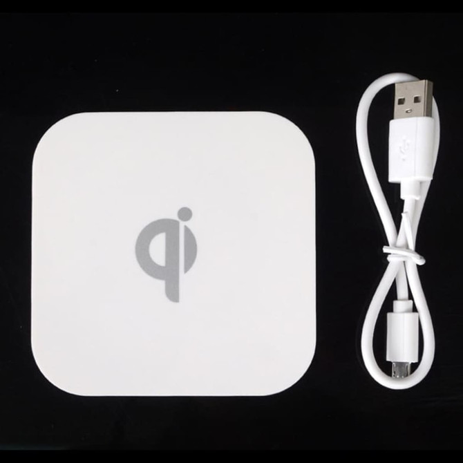 A square-shaped white wireless charger with a USB cable, featuring a simple logo on its surface. A square-shaped white wireless charger with a USB cable, featuring a simple logo on its surface.