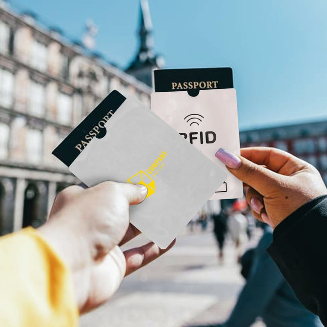 A grey RFID passport holder and a clear passport holder, both labelled "PASSPORT," held against a city backdrop.