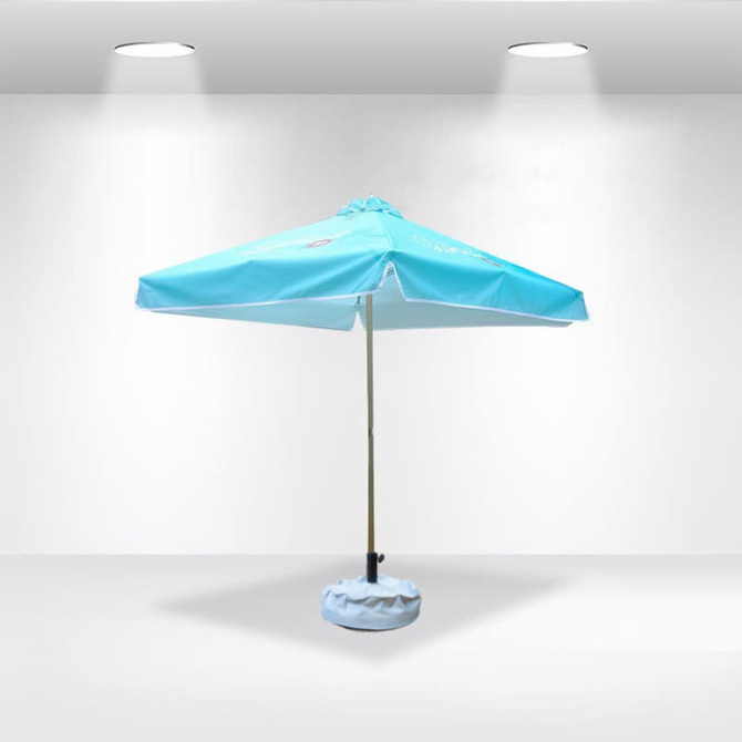 A light blue patio umbrella with valances and a base, featuring a logo, set against a plain background.