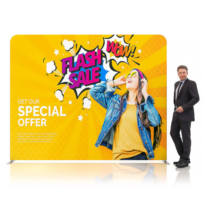 A vibrant, yellow fabric display wall featuring a graphic design with text and a person wearing sunglasses. It has a logo.