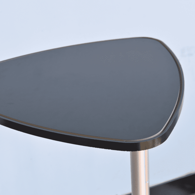 A triangular black tabletop with a smooth finish, mounted on a silver pole. A triangular black tabletop with a smooth finish, mounted on a silver pole.