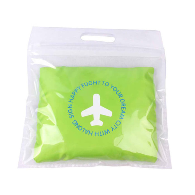 A green compressed travel bag in a transparent packaging with a circular design and a logo.