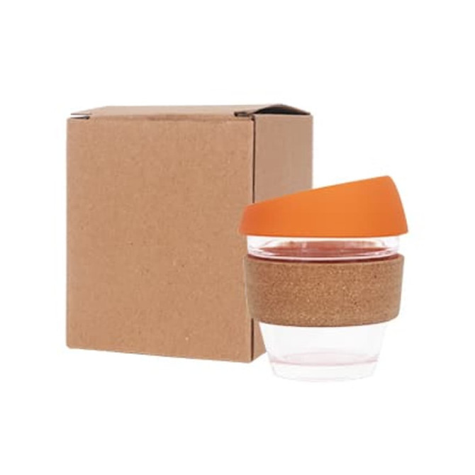A drink bottle with a cork band, clear glass body, and an orange silicone lid, placed next to a brown cardboard box.