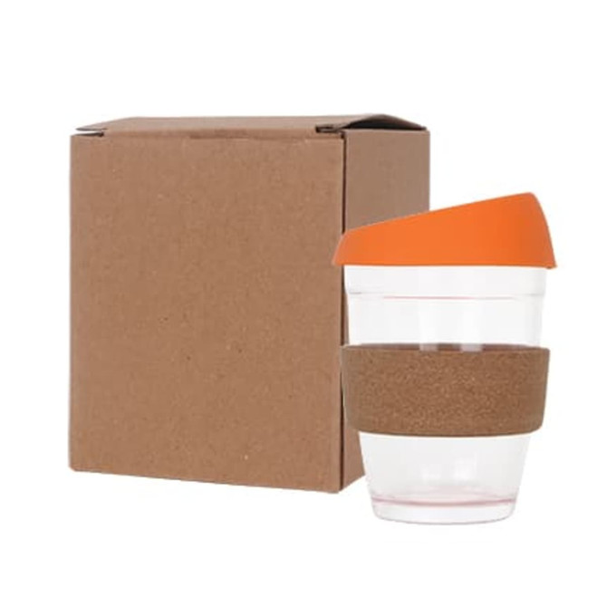 A reusable glass coffee cup with a cork band and an orange lid, next to a brown box.