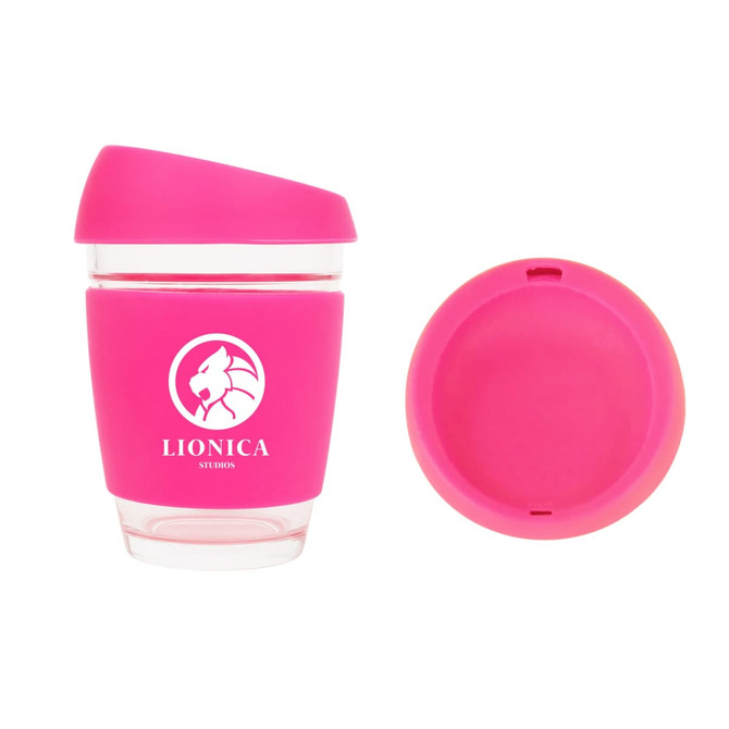 A reusable 12 OZ glass coffee cup in pink with a silicone sleeve and a matching lid, featuring a logo.