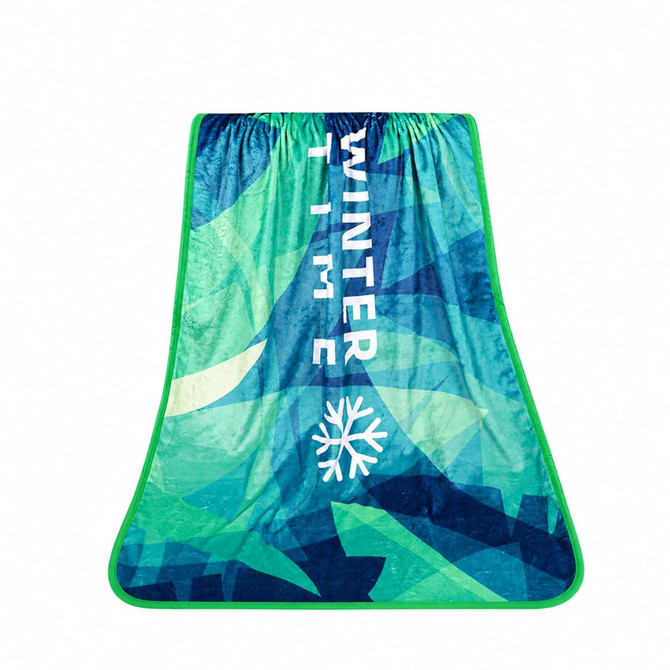 A flannel blanket in shades of blue and green with a winter theme and a logo.