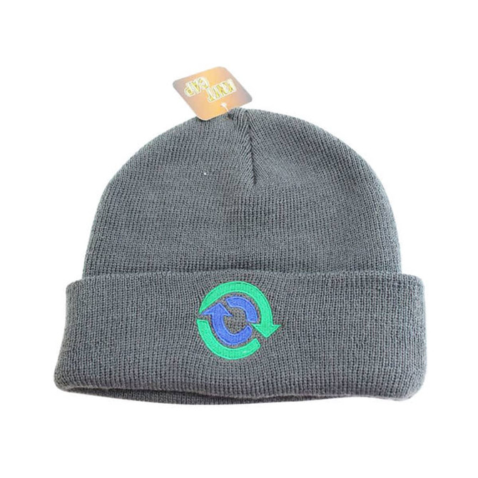 A grey knitted beanie with a folded cuff and a logo on the front.