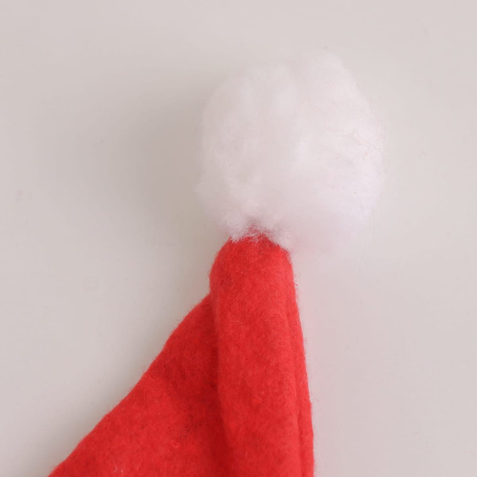 A red Santa hat with a fluffy white pom-pom at the tip. The hat is made of soft felt material.