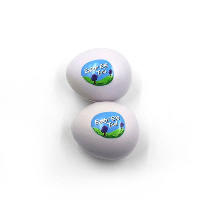 Two white egg-shaped stress relievers with a logo featuring a scenic design.