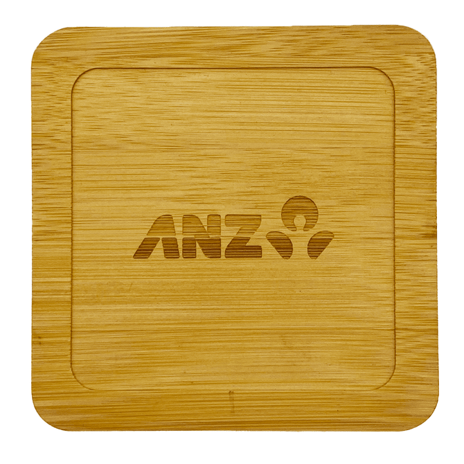 A bamboo coaster with a square shape, featuring an engraved logo. The colour is light brown.