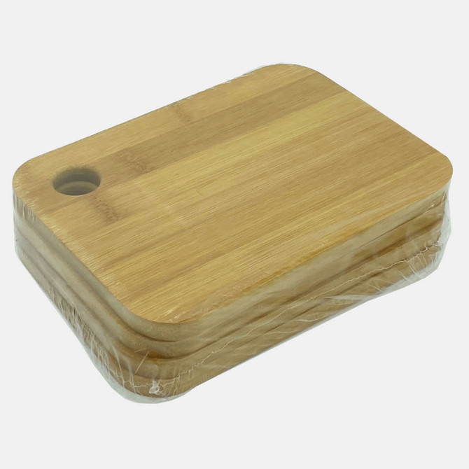 A bamboo cutting board in a stack, featuring a rounded edge and a hole for hanging. Wrapped in plastic.