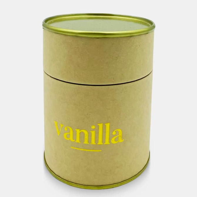 A small, round candle in a brown container with a gold lid, featuring "vanilla" in yellow text.