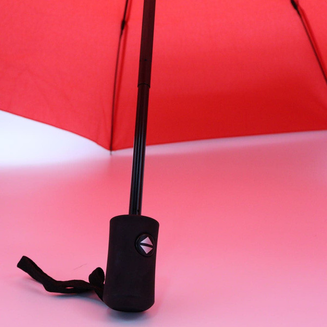 A red umbrella with a black handle and strap, featuring a logo on the handle.