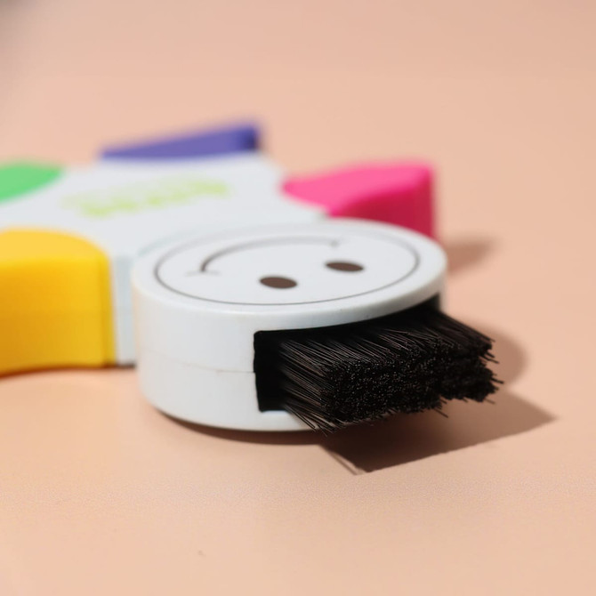 A highlighter in the shape of a star, featuring pink, yellow, green, and blue tips, with a smiley face on the body. A highlighter in the shape of a star, featuring pink, yellow, green, and blue tips, with a smiley face on the body.