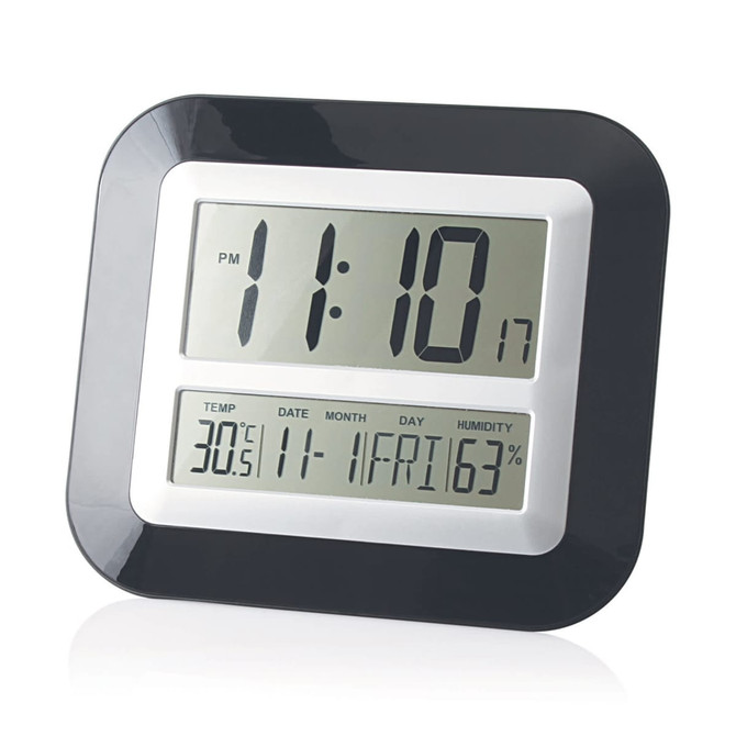 A wall desk clock with a black and silver design displaying time, temperature, date, and humidity.
