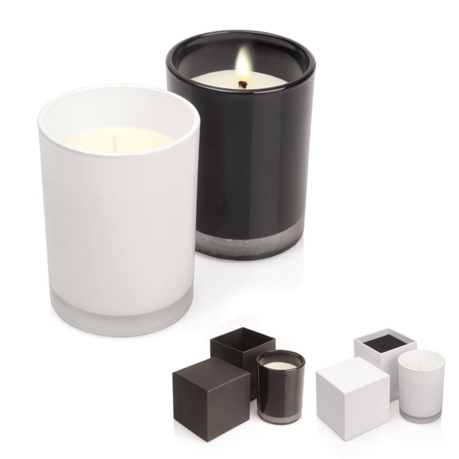 Two candles in glass holders, one white and one black, with a lit wick on the black candle. Includes additional square designs.