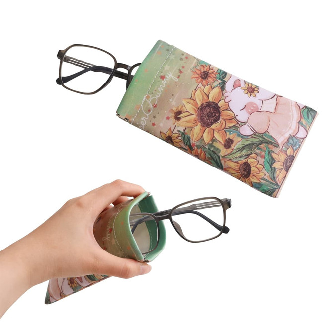 A full colour print glasses pouch with floral and animal designs in green and pastel tones, featuring a logo.