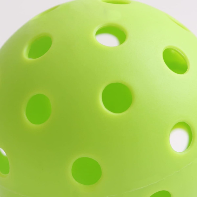 A bright green pickleball with multiple perforations, showcasing a smooth surface and spherical shape.