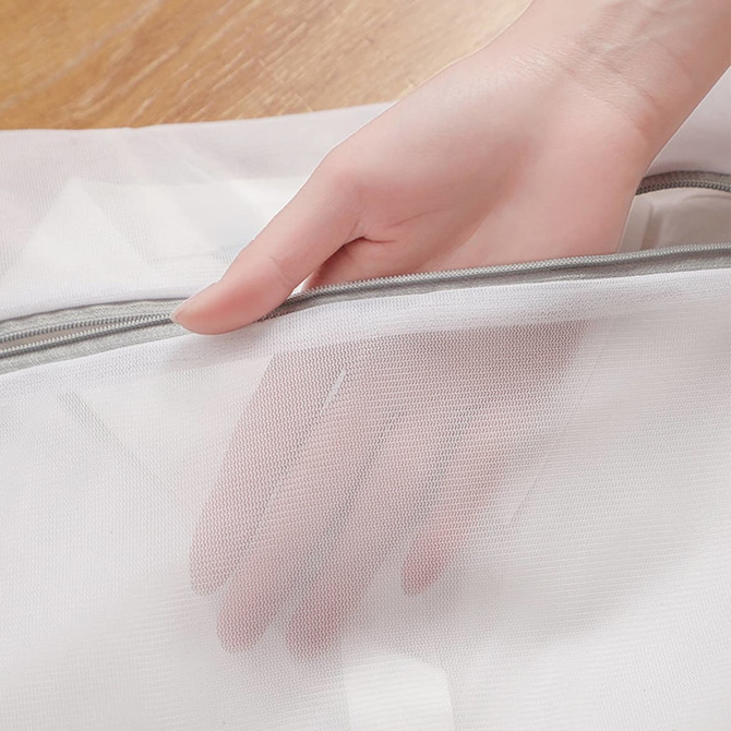 A white mesh laundry bag with a hand holding the zipper, showcasing its fine mesh material.