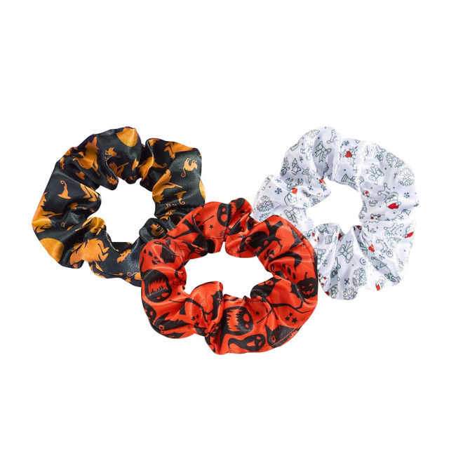 Three hair scrunchies in black with orange patterns, red with skulls, and white with playful designs, featuring a logo.