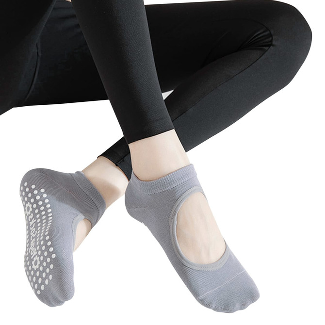 Open top yoga socks in grey featuring grip dots on the soles, accompanied by black leggings.