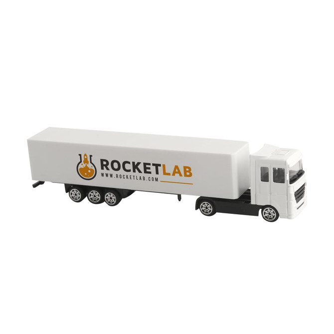 A white toy truck with a grey cab and a large, white trailer featuring a logo.