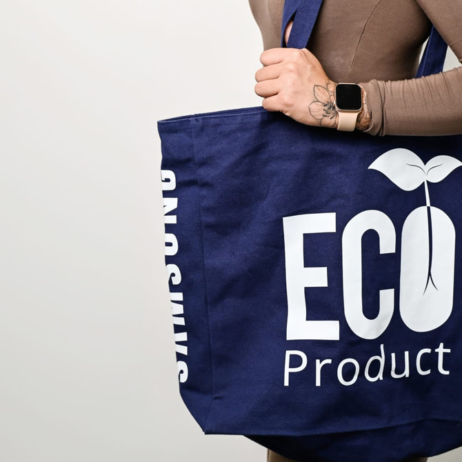 A navy recycled tote bag with a logo and text. It has sturdy handles and a spacious design.