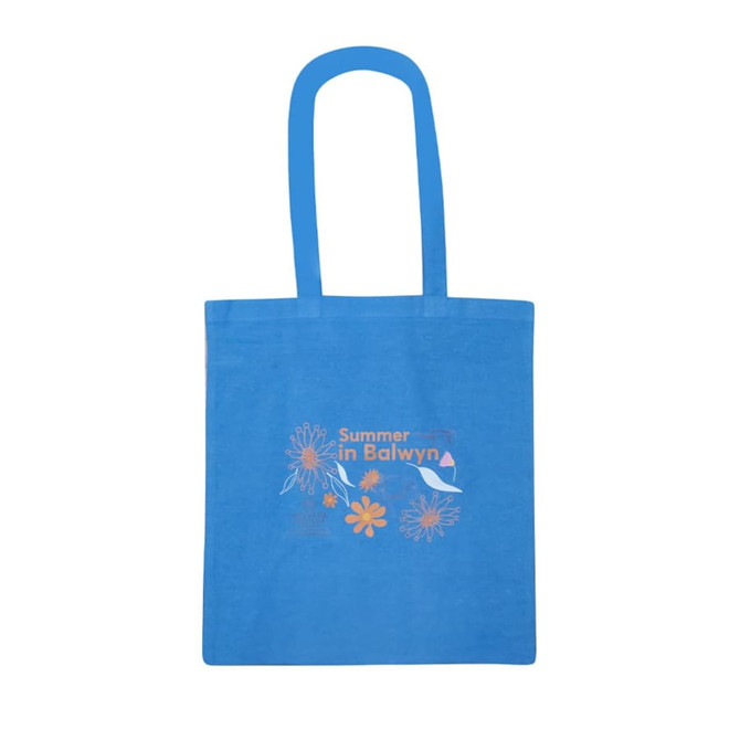 A blue tote bag featuring colourful floral designs and a logo. It has long handles for easy carrying.