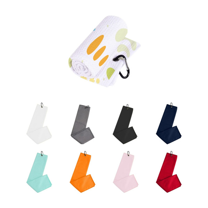 A rolled waffle golf towel in white with a design and various unfolded towels in teal, orange, pink, red, navy, black, and grey.