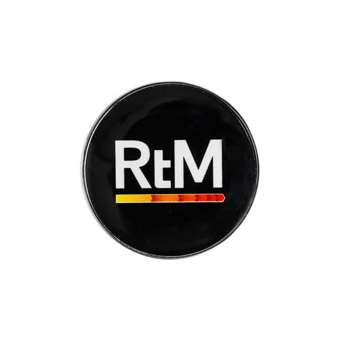 A 25mm round golf ball marker featuring a black background and a logo in white and orange-yellow colours.