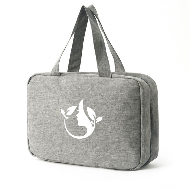 A large grey toiletry bag with two handles and a logo featuring nature-themed elements.