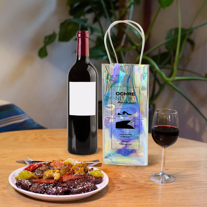 A PVC laser wine ice bag in iridescent colours next to a bottle of red wine and a plate of food on a wooden table.