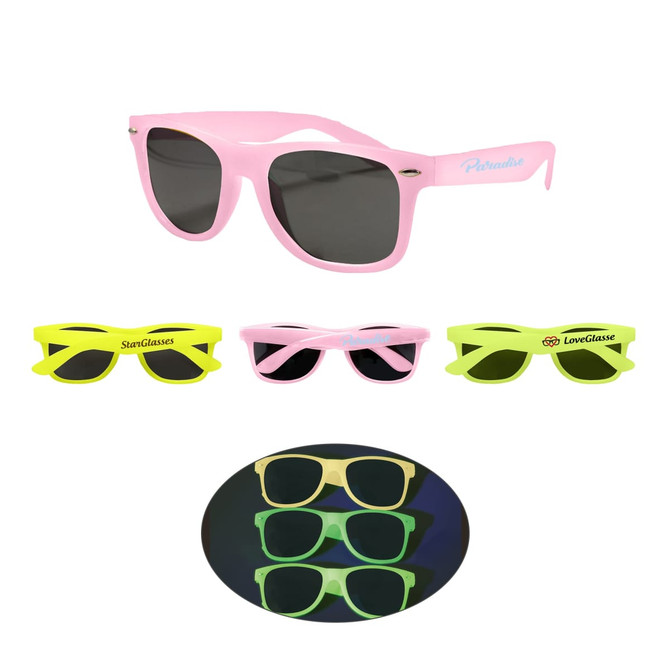 Glow in the dark sunglasses in pink and neon green, featuring different styles and a logo on some pairs.