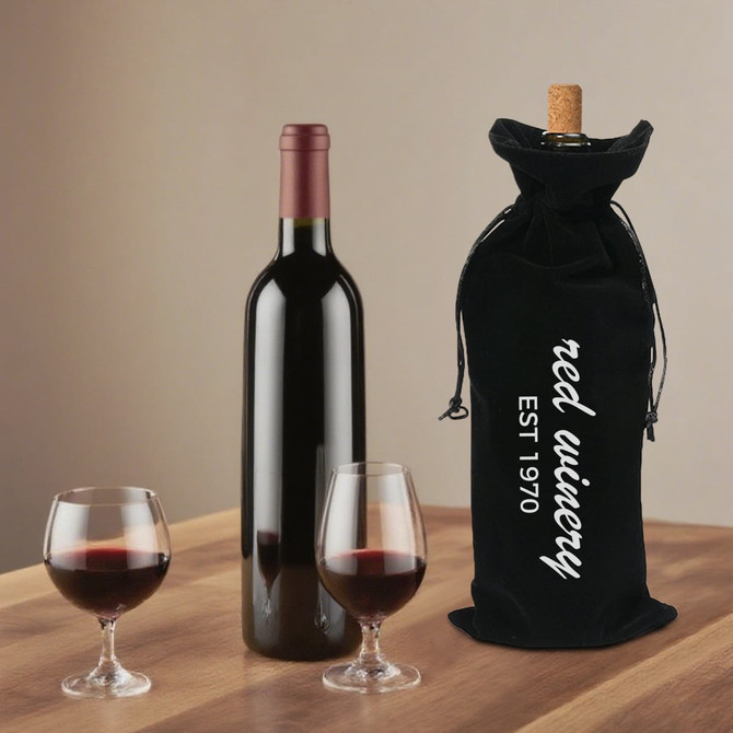A drink bottle bag in black flannel, designed for wine, with a vineyard logo. Two wine glasses with red wine are beside it. A drink bottle bag in black flannel, designed for wine, with a vineyard logo. Two wine glasses with red wine are beside it.