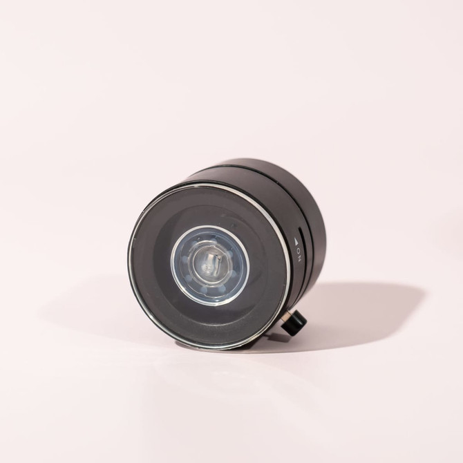 A black vacuum suction magnetic phone stand with a glossy finish and a circular shape, featuring a small control knob.