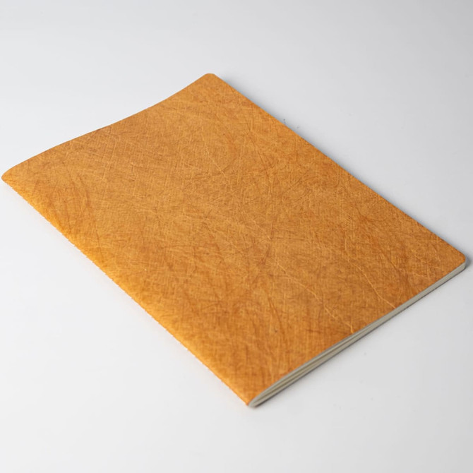 A notebook with a textured orange cover, featuring a simple design without visible branding.
