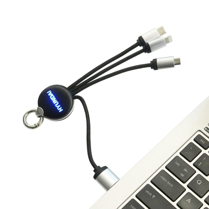 A round-shaped light-up charging cable with multiple connectors, featuring a keyring attachment, displayed near a laptop.