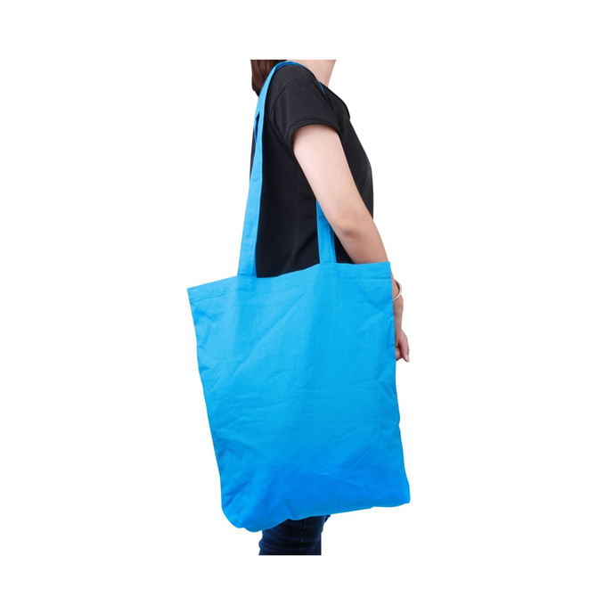 A bright blue long handle cotton bag is held by a person, featuring an unbranded design. A bright blue long handle cotton bag is held by a person, featuring an unbranded design.