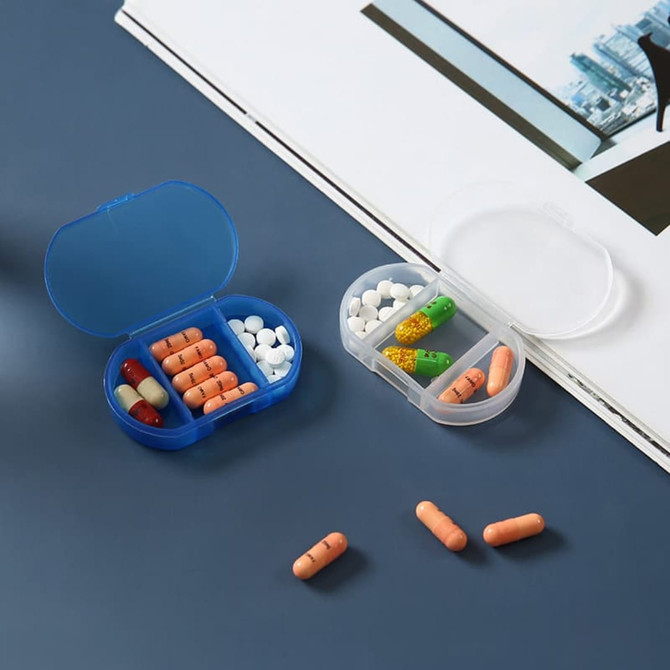 A blue and a clear pill box with multiple compartments, containing various coloured tablets and capsules.