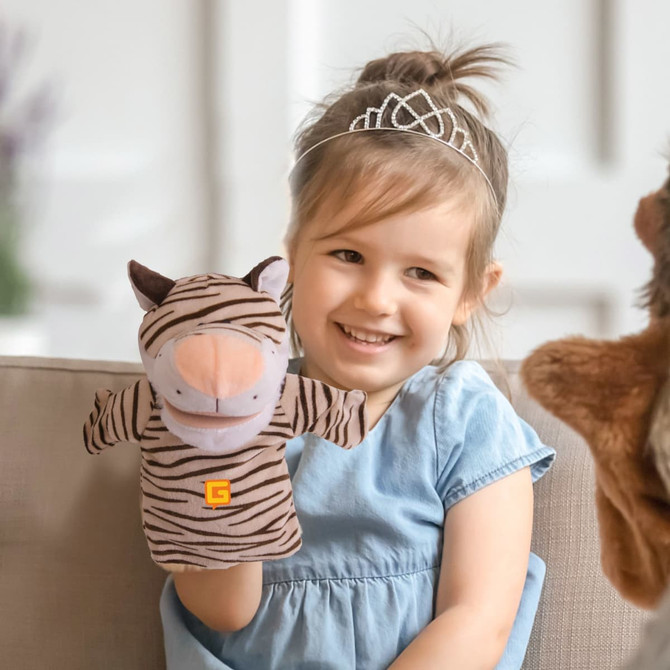 A plush tiger hand puppet with a light brown and dark brown striped design held by a smiling child.