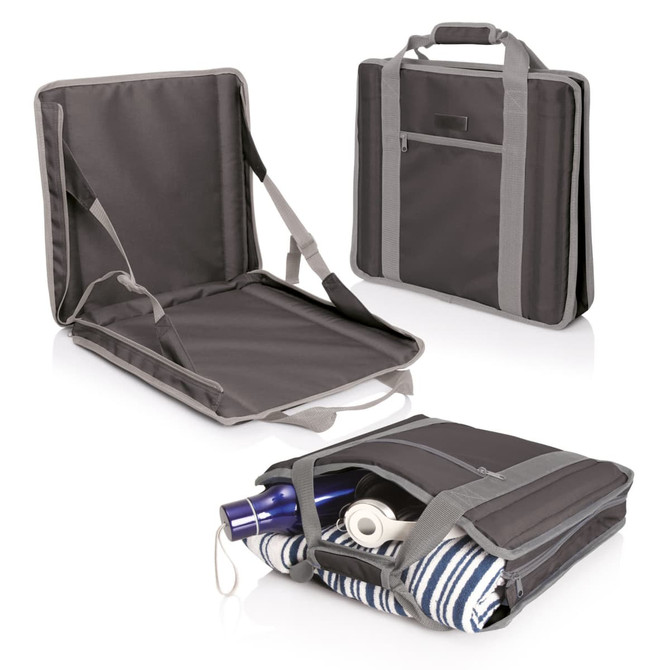 A dark grey stadium seat carry bag with handles and a side pocket, partially showing a drink bottle and a blanket inside.