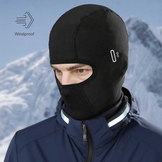 A black winter balaclava cycling face mask with an integrated windproof feature, worn by a person against a mountainous background.