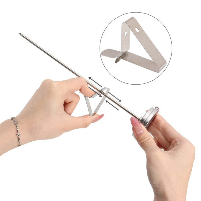 A stainless steel deep fry thermometer with an adjustable clip, held by a hand, showcasing its sleek design.