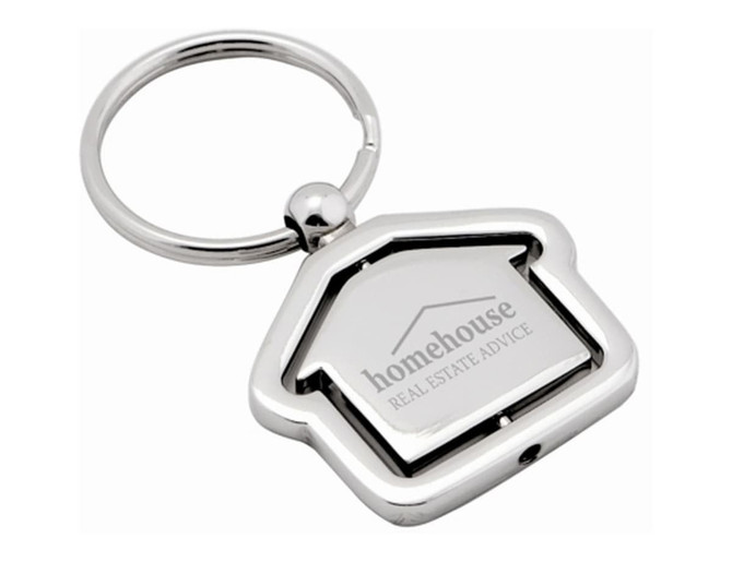 A silver keyring shaped like a house, featuring a logo on the front and a circular keyring attachment.