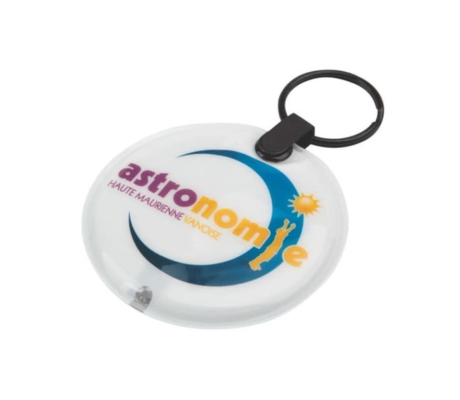 A circular white keyring with a black keychain attachment, featuring a logo that includes blue and yellow elements.