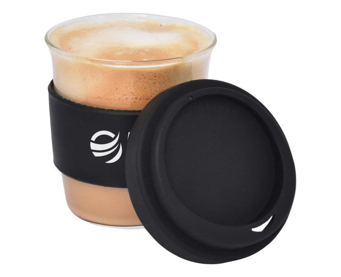 A reusable coffee cup in clear glass, featuring a black silicone sleeve and lid, containing a frothy beverage.