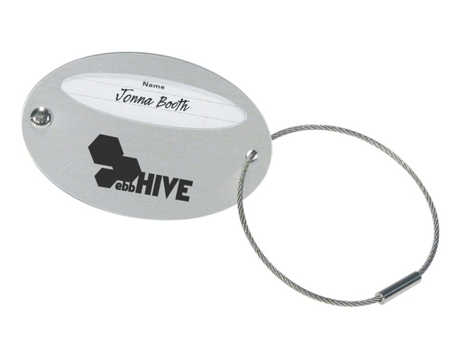 Oval luggage tag in silver with a wire loop and a section for personal details, featuring a logo.